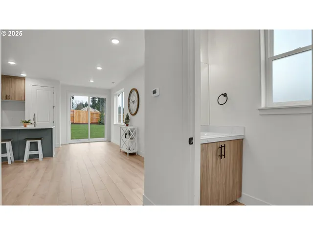 a kitchen with kitchen island a stove a refrigerator a sink and a dining table with wooden floor