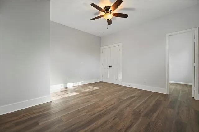 a view of an empty room with window and a ceiling fan