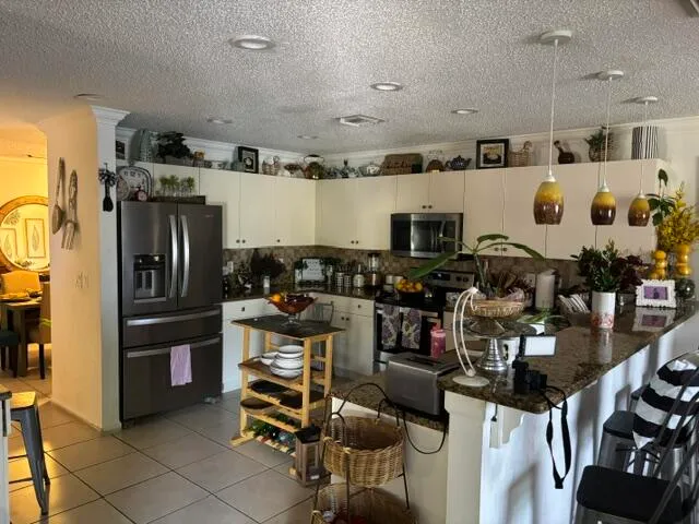 a kitchen with stainless steel appliances kitchen island granite countertop a refrigerator and stove top oven