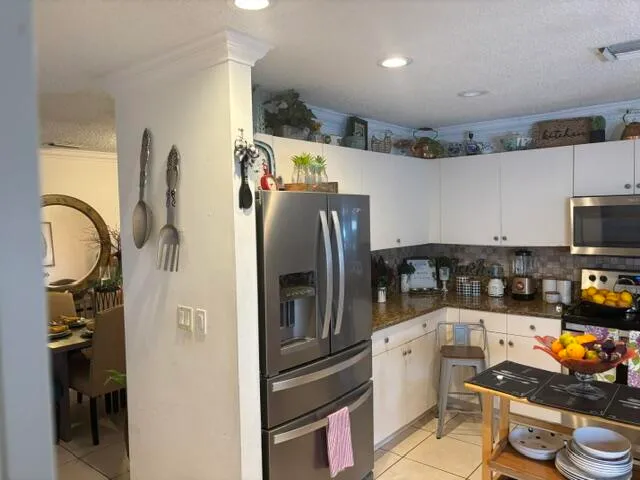 a kitchen with stainless steel appliances granite countertop a refrigerator and a stove top oven