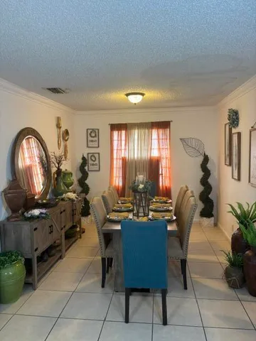 a living room with furniture a large window and a potted plant