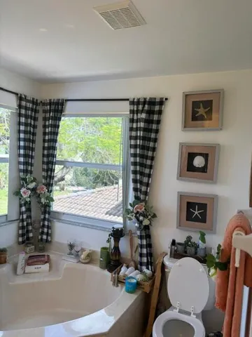 a bath room with a couch and a large window