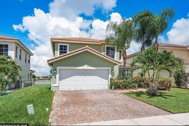 a front view of a house with a yard and garage