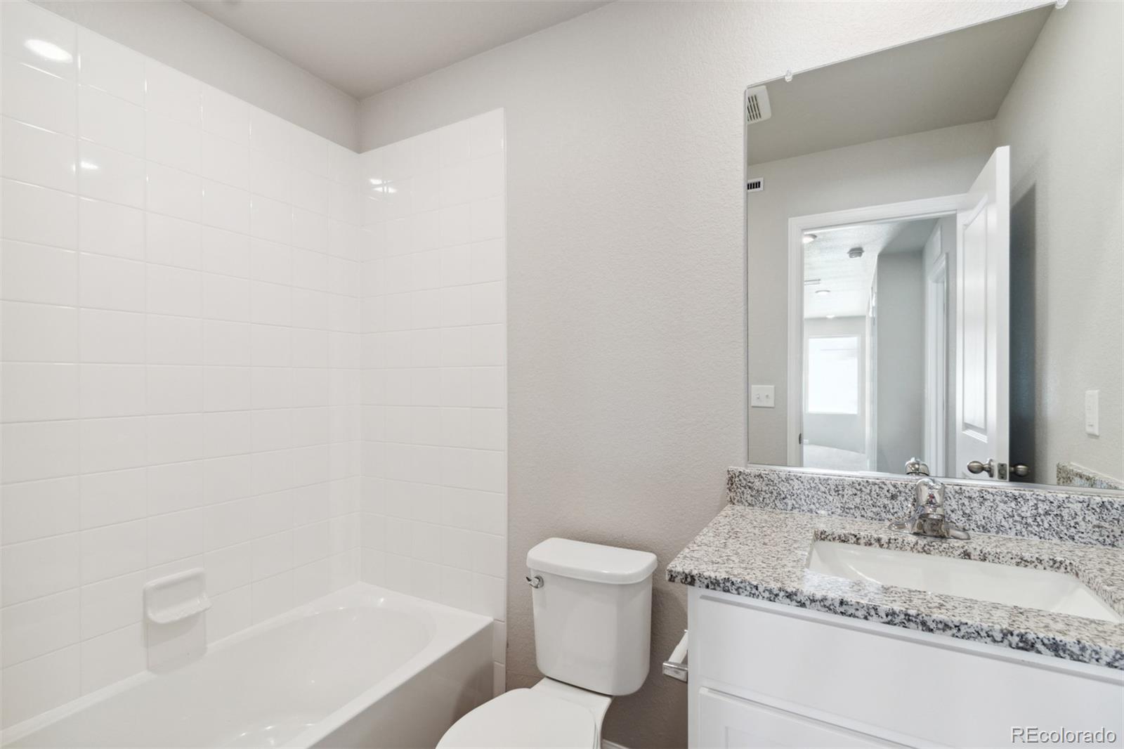 7402 Crystal Avenue Frederick, CO 80530 - Photo 14 of 26 a bathroom with a granite countertop sink a toilet and shower