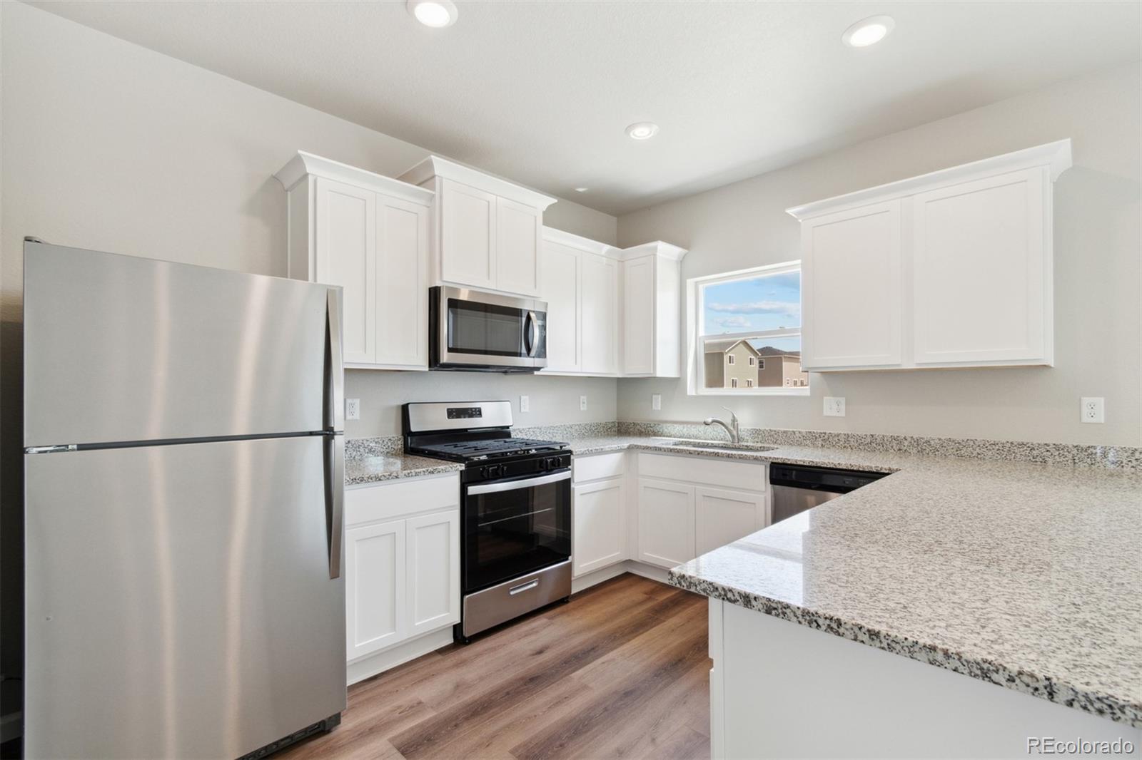 7402 Crystal Avenue Frederick, CO 80530 - Photo 4 of 26 a kitchen with a refrigerator stove and microwave