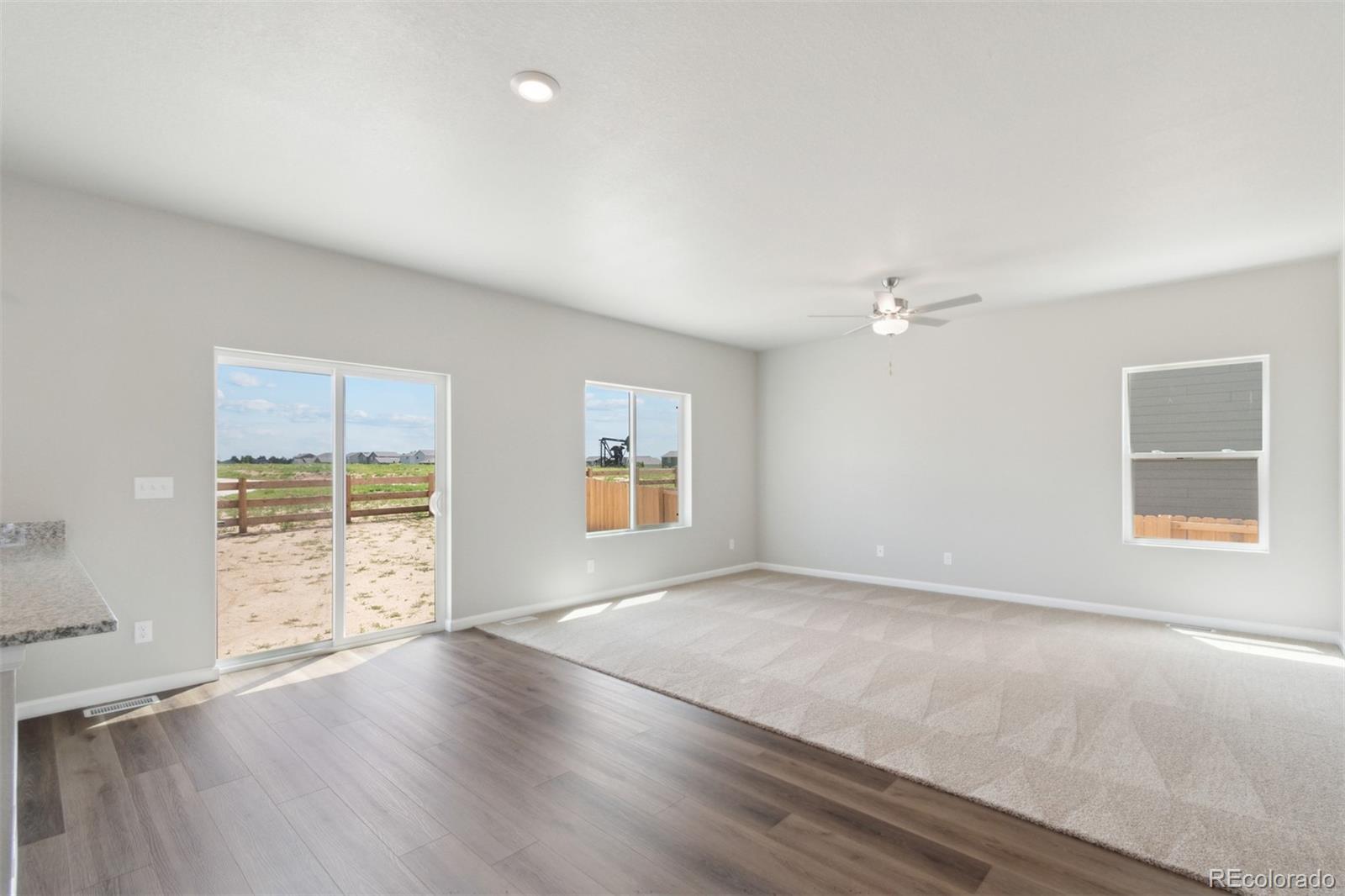 7402 Crystal Avenue Frederick, CO 80530 - Photo 7 of 26 an empty room with wooden floor and windows