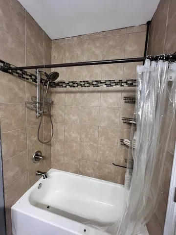 a bathroom with a shower and a bath tub