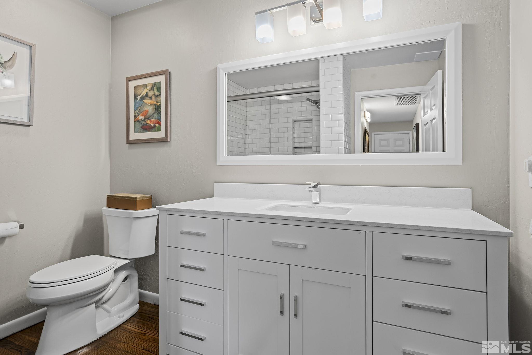 1953 South Villa Way Reno, NV 89509 - Photo 20 of 31 a bathroom with a toilet a sink and mirror