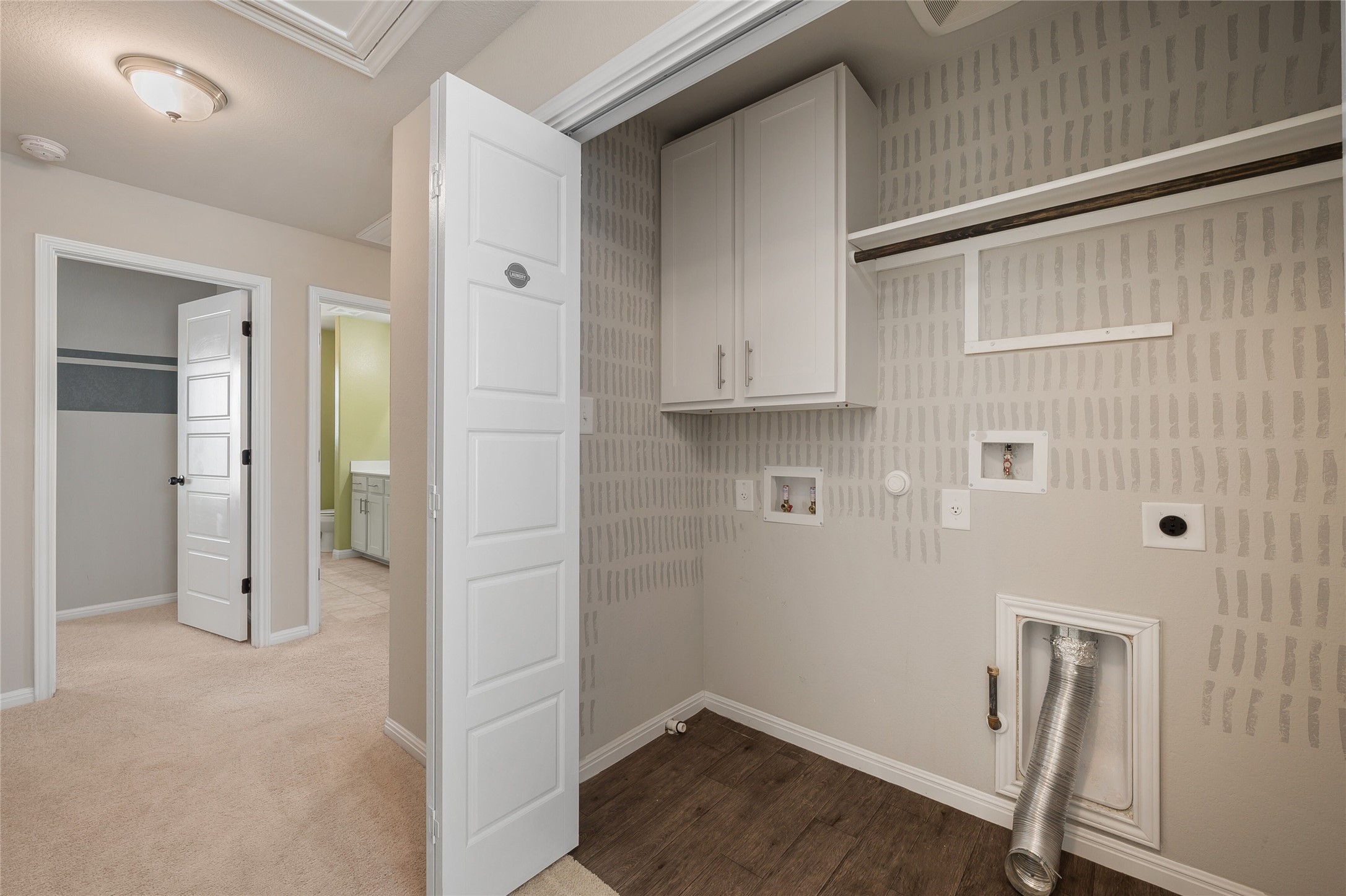 101 Lambert Street Leander, TX 78641 - Photo 28 of 33 A dedicated laundry space offers convenience with built-in cabinetry and durable wood flooring.