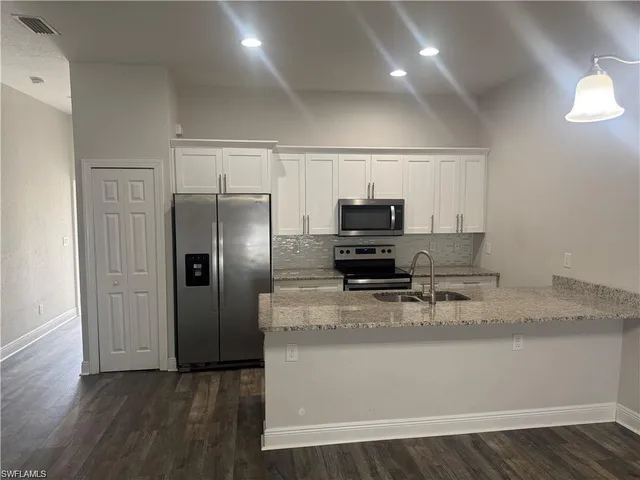 a kitchen with kitchen island a counter top space cabinets and stainless steel appliances