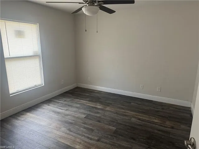 a view of a room with wooden floor and a window