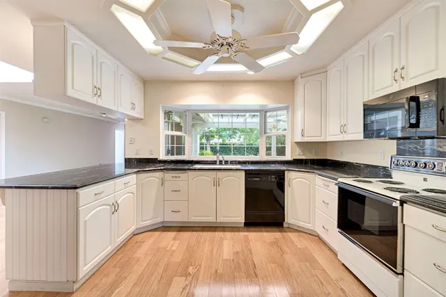 a kitchen with stainless steel appliances granite countertop a stove a sink and a microwave