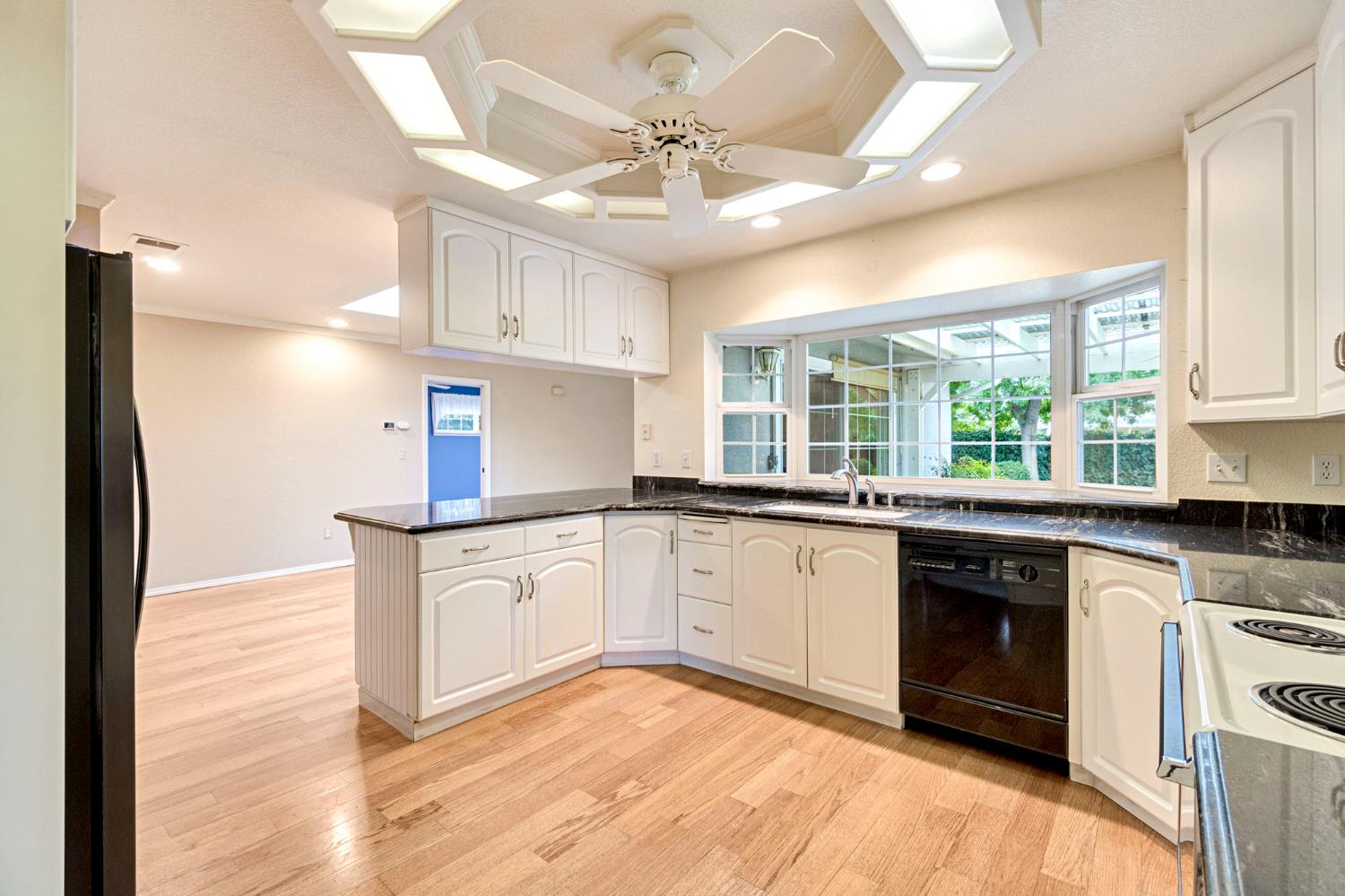 2020 Short Drive Hanford, CA 93230 - Photo 3 of 38 a kitchen with stainless steel appliances granite countertop a sink cabinets wooden floor and a window