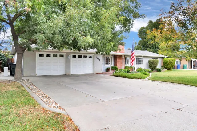 a front view of a house with a yard and a garage