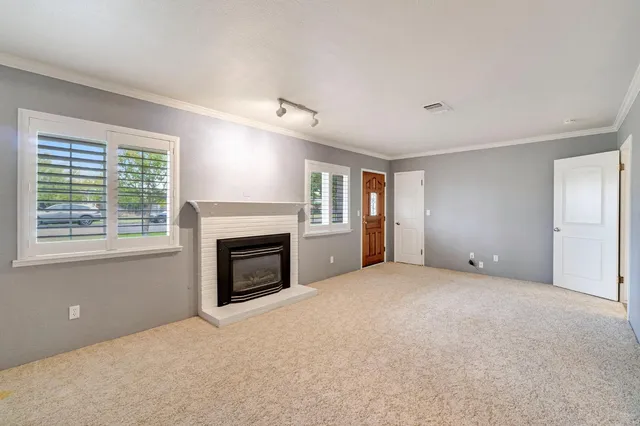 a view of empty room with a fireplace and windows