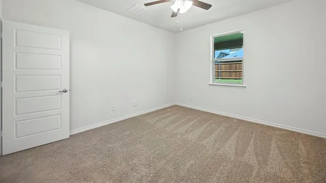 wooden floor in an empty room with a chandelier fan