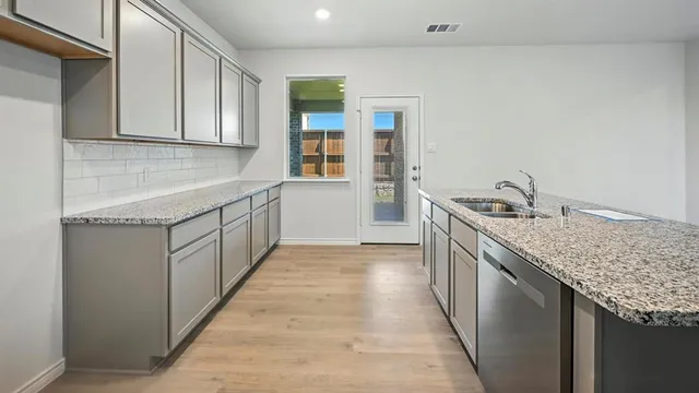 a kitchen with granite countertop wooden cabinets and a stove top oven