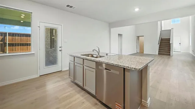a kitchen with granite countertop cabinets a sink and dishwasher