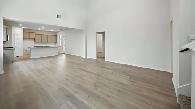 a view of an empty room with a kitchen