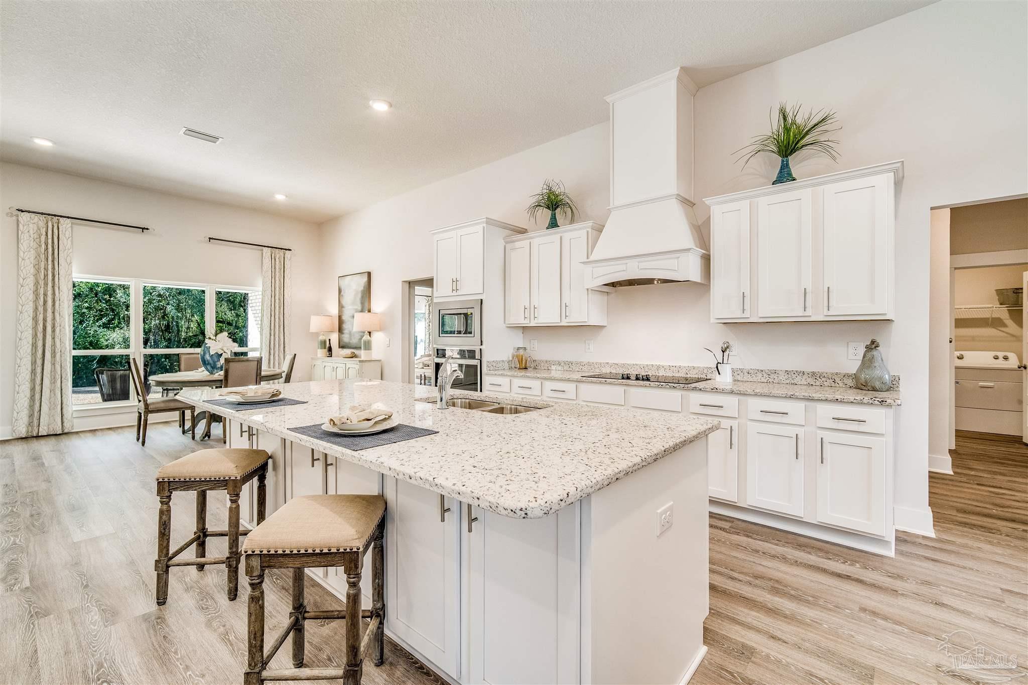 5780 Windham Road Milton, FL 32570 - Photo 14 of 37 a kitchen with granite countertop white cabinets and chairs