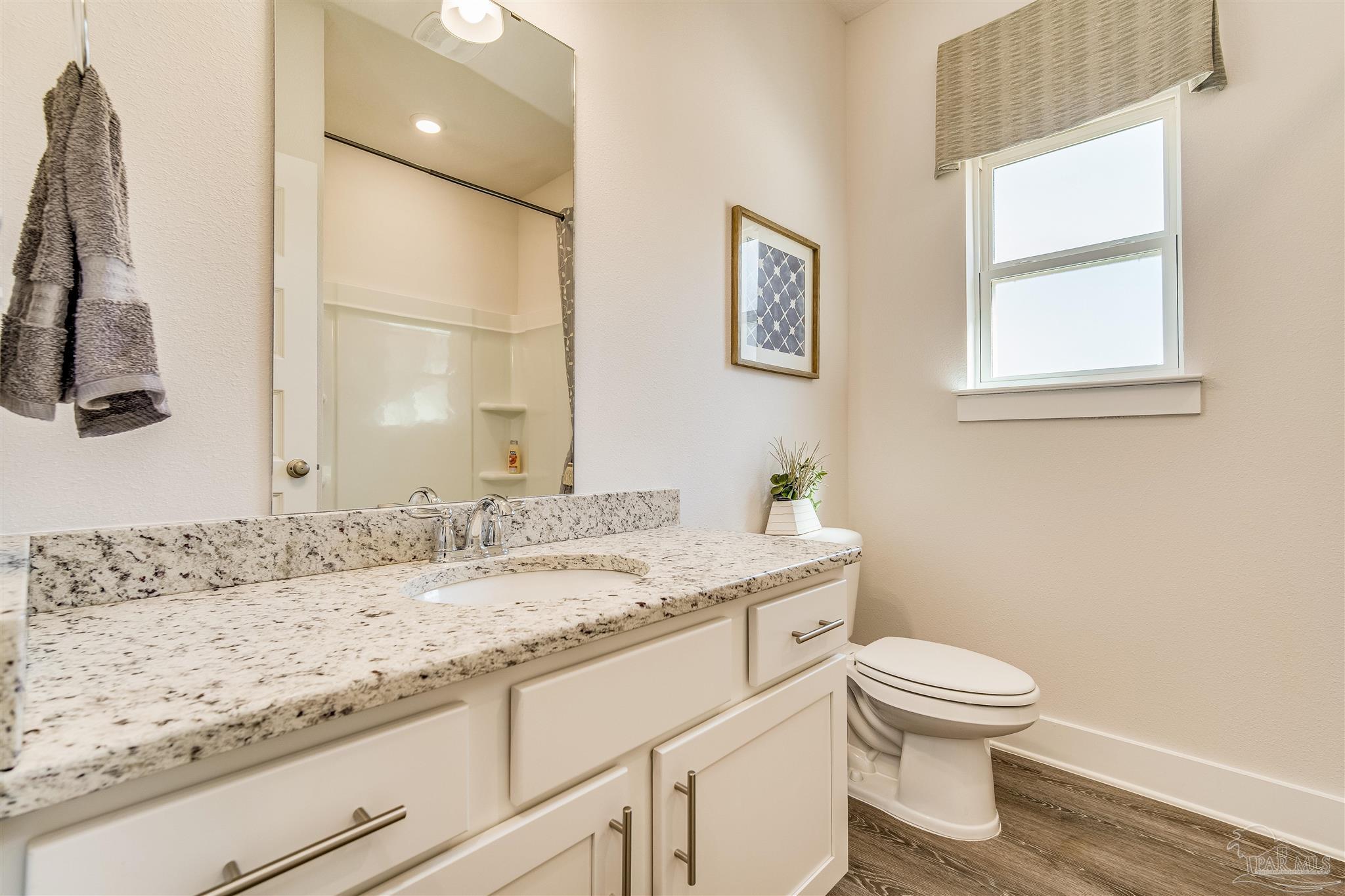 5780 Windham Road Milton, FL 32570 - Photo 24 of 37 a bathroom with a granite countertop sink a toilet and a window