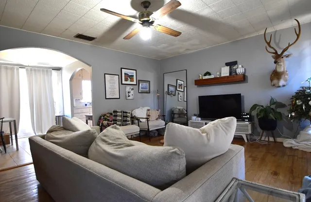 a living room with furniture a fireplace and a chandelier