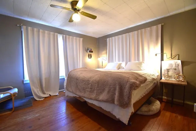 a bed sitting in a spacious bedroom next to a window