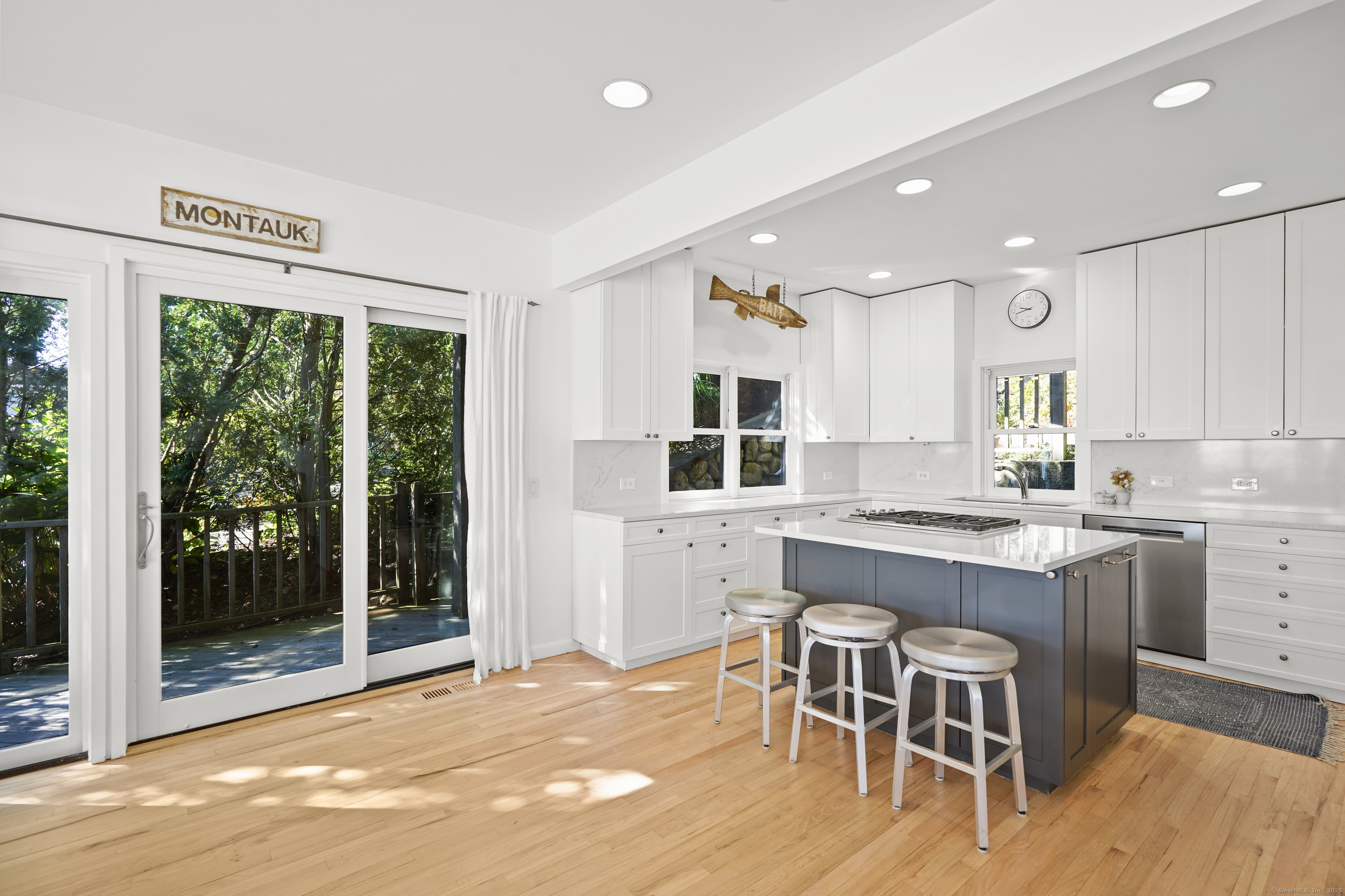 64 Ocean Drive East Stamford, CT 06902 - Photo 13 of 38 a kitchen with white cabinets and wooden floor