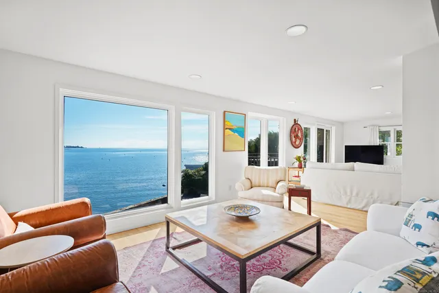 a living room with furniture a fireplace and a large window