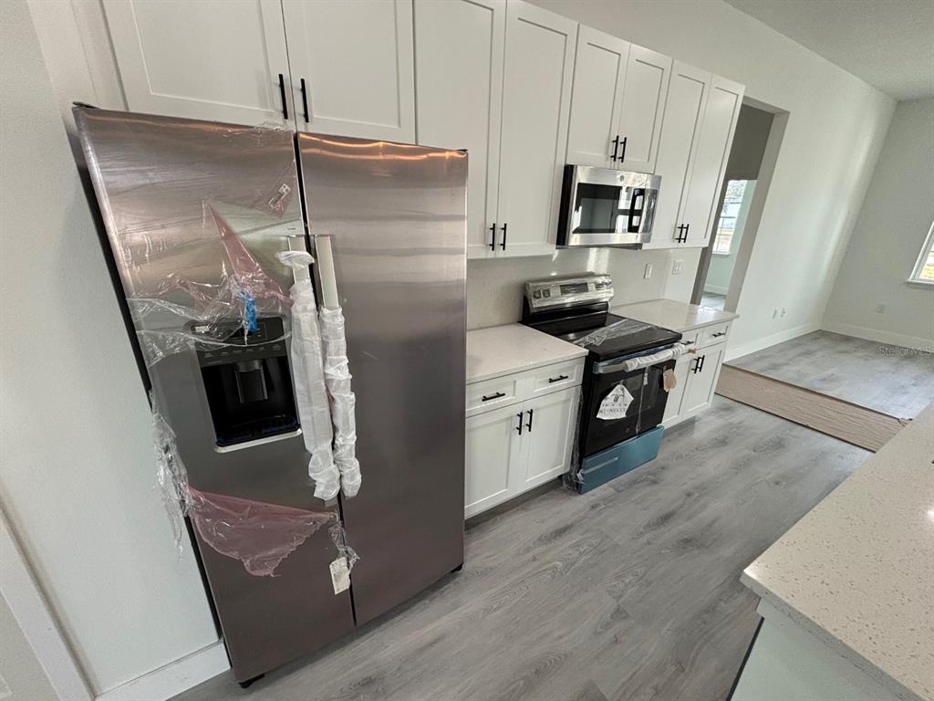 7518 Southwest 128th Street Ocala, FL 34473 - Photo 5 of 5 a kitchen with stainless steel appliances granite countertop a refrigerator a stove and a sink