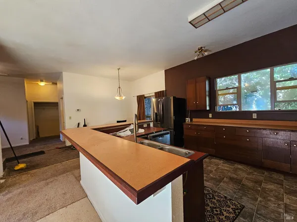 a room with stainless steel appliances kitchen island granite countertop a sink stove and refrigerator