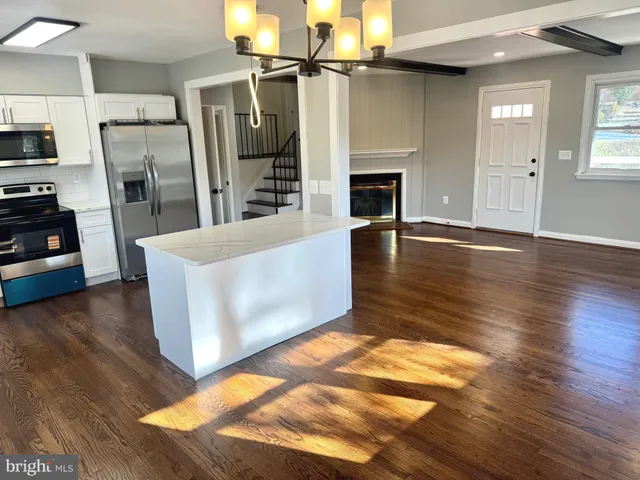 a view of a kitchen with furniture and wooden floor