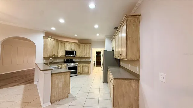 a kitchen with stainless steel appliances granite countertop a refrigerator sink and stove