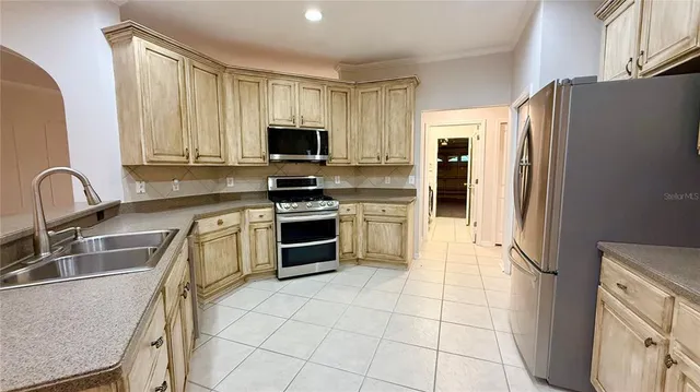 a kitchen with a sink a counter top space stainless steel appliances and cabinets