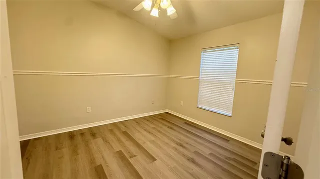 a view of an empty room with wooden floor