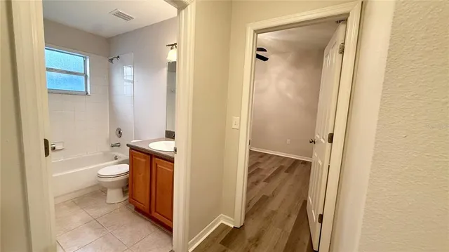 a bathroom with a granite countertop sink toilet a mirror and shower