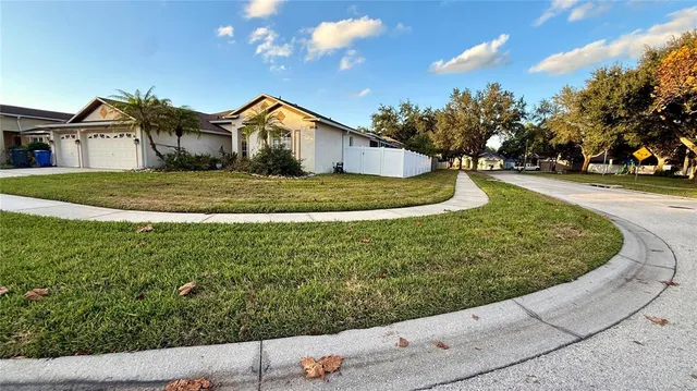 a view of a white house with a yard and potted plants