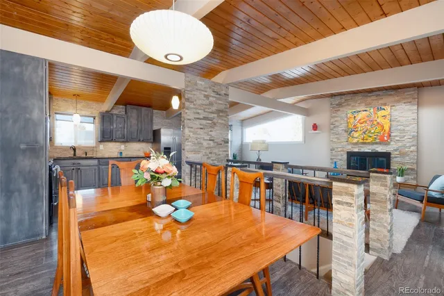 a kitchen with stainless steel appliances wooden floor dining table and chairs