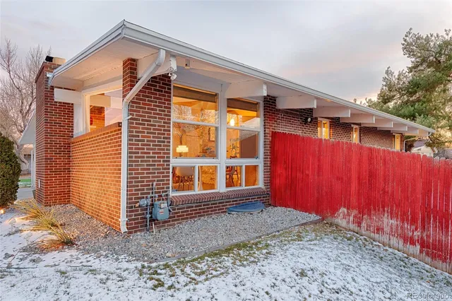 a view of a house with backyard and wooden fence