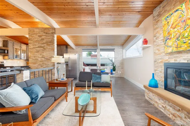 a living room with fireplace furniture and a large window