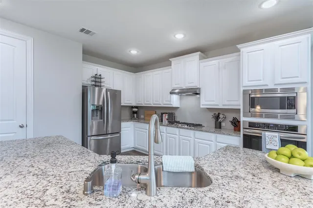 a kitchen with a refrigerator and a sink