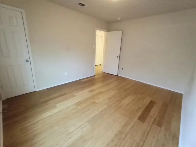 an empty room with wooden floor and white walls