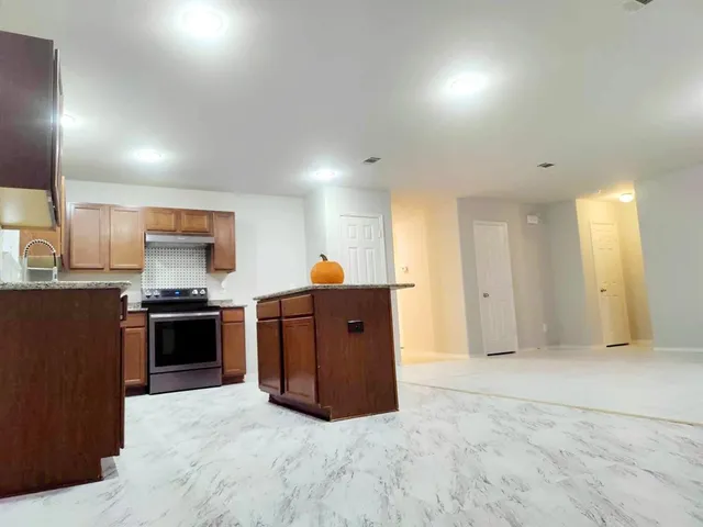 a kitchen with stainless steel appliances granite countertop a stove and a refrigerator