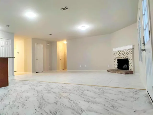 an empty room with fireplace and a window