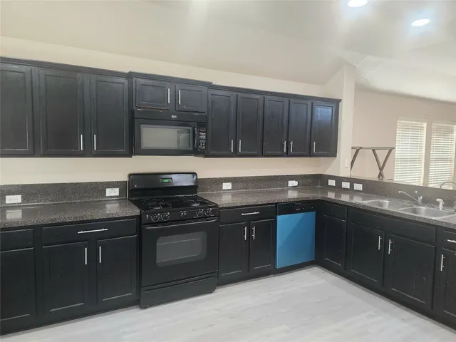 a kitchen with granite countertop wood cabinets and stainless steel appliances