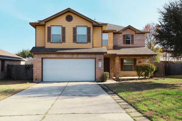 a front view of a house with yard and trees