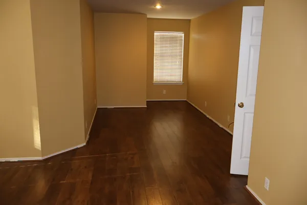 a view of a small space with wooden floor and a window