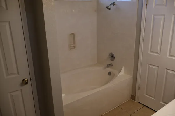 an empty room with wooden floor cabinet and closet area