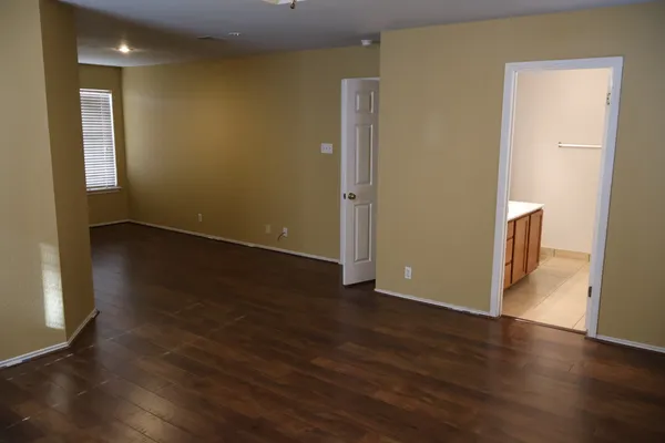 an empty room with wooden floor and a window