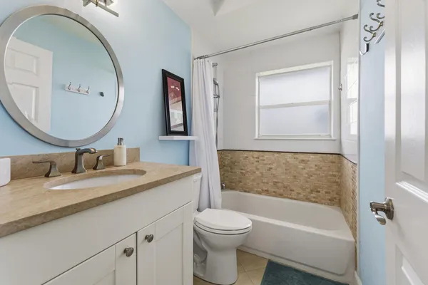 a bathroom with a granite countertop sink toilet and a mirror
